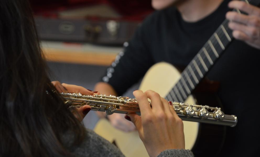 Leerlingen musiceren samen op gitaar en dwarsfluit