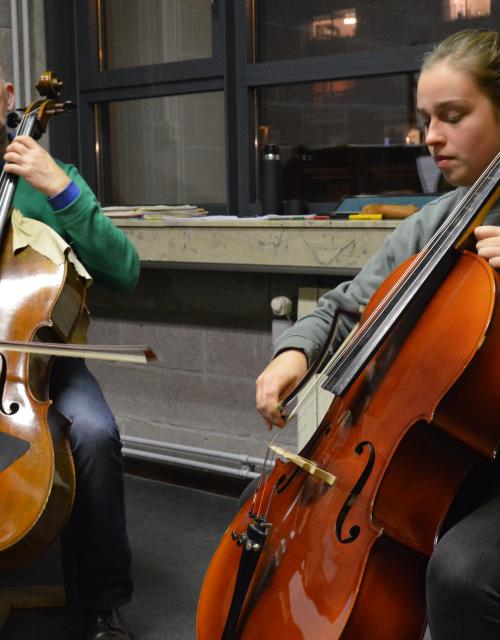 Leerkracht en leerlingen spelen samen cello