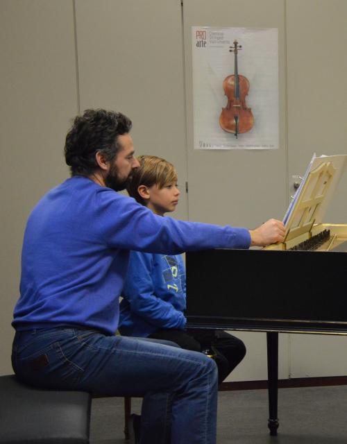 Leerling en leerkracht spelen klavecimbel
