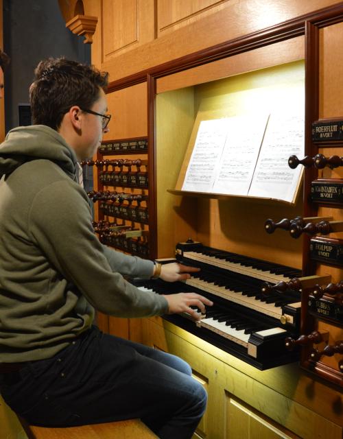 Leerling en leerkracht spelen samen op een orgel