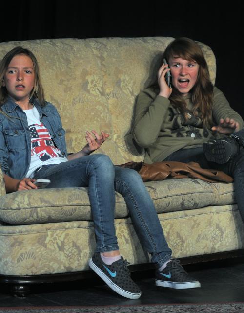 Twee meisjes zitten in een sofa op het podium