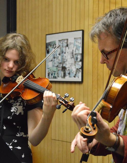Leerling en leerkracht spelen samen viool