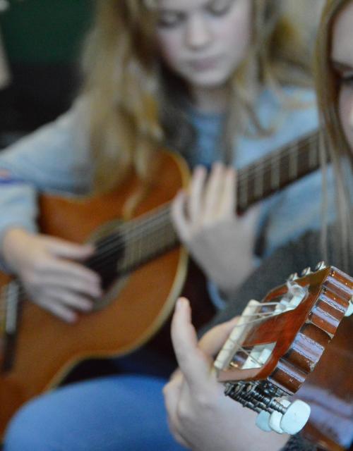 Leerlingen spelen gitaar